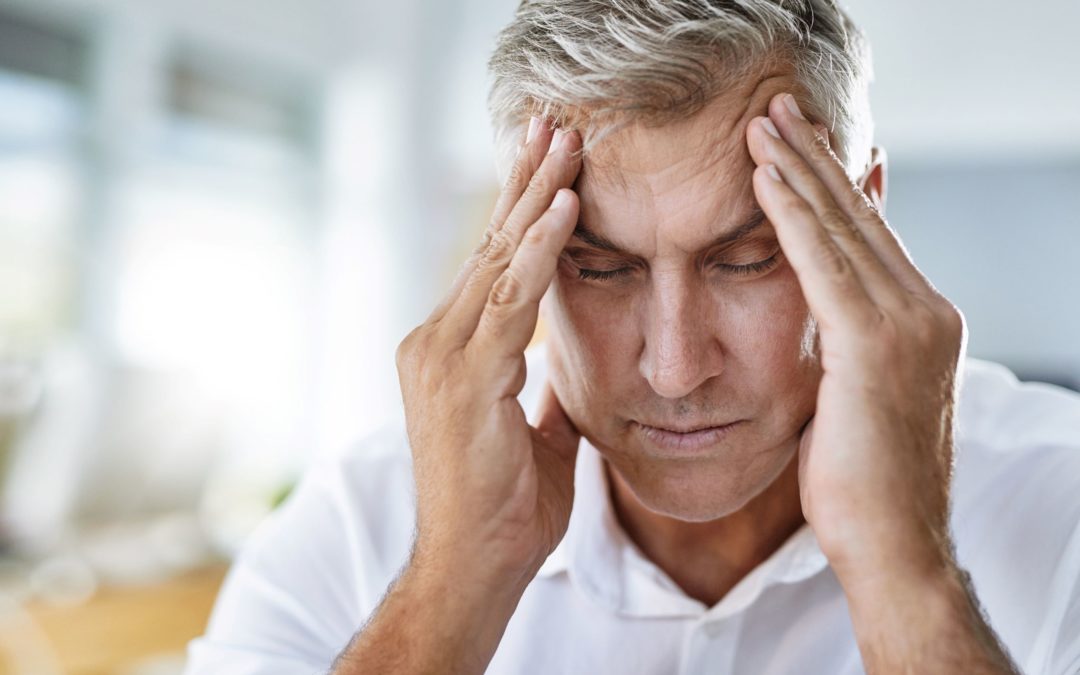 In some situations, a headache might be caused by a serious underlying medical condition, such as a brain tumor, an aneurysm, a blood clot, an impending stroke, or meningitis. In this image, a man is sitting at a table with his hands on his temples.